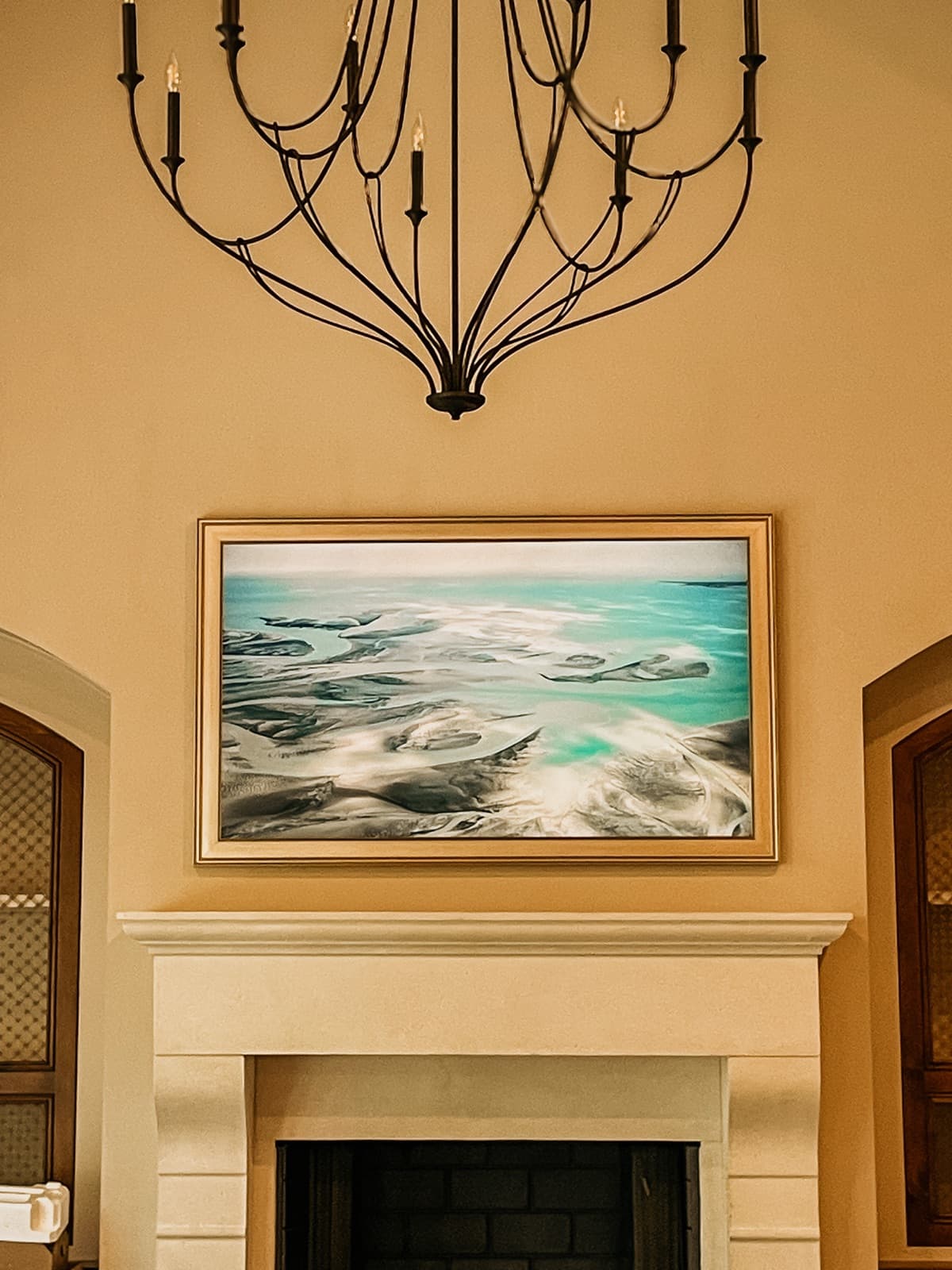Samsung Frame TV in Art Mode with custom champagne frame above a stone fireplace