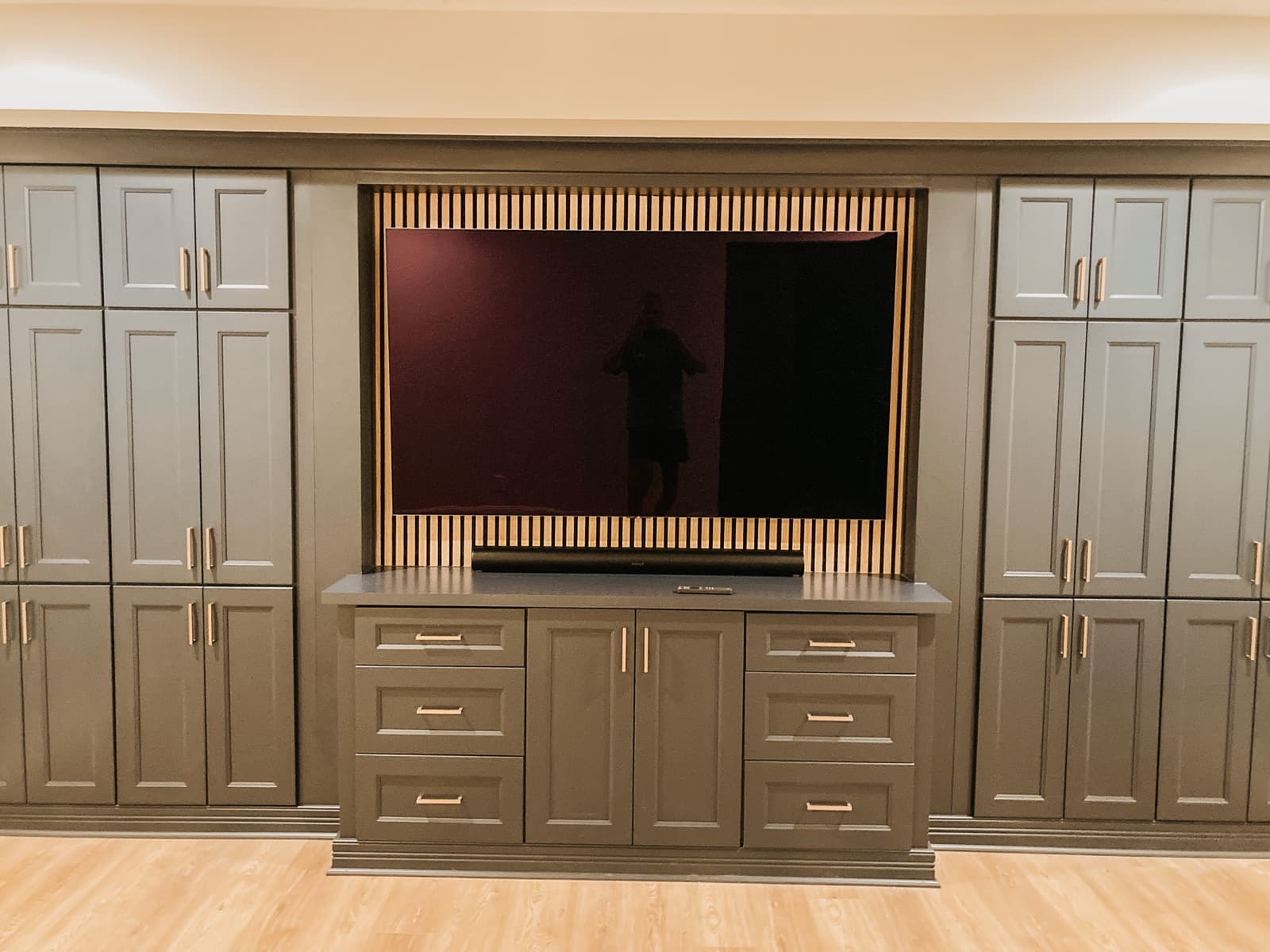 TV mounted on custom wood paneling with a Sonos Arc soundbar